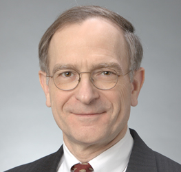Middle-aged man with glasses, short light brown hair, wearing a suit, white shirt, and patterned tie, posing against a neutral background—an experienced lawyer in Chicago specializing in intellectual property law.