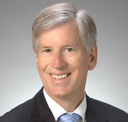 A middle-aged man with gray hair in a suit and tie poses for a professional headshot against a plain background, reflecting the polished image of top chicago lawyers at leading law offices.