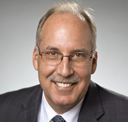 Middle-aged man with glasses, a mustache, and short light hair, wearing a suit and tie, smiling at the camera—typical of professionals found at leading Chicago law offices.