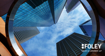 View looking up at modern skyscrapers through a circular architectural structure, under a blue sky with scattered clouds. Showcasing corporate law office excellence, text reads "FOLEY FOLEY & LARDNER LLP" in the bottom right corner.