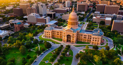Aerial view of the Texas State Capitol building, surrounded by trees and city buildings in Austin, Texas, during daylight—a striking scene for law offices specializing in intellectual property law.
