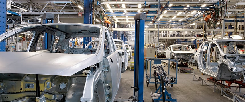 Partially assembled car bodies move along an automated production line inside a large, brightly lit automotive factory, much like the efficient teamwork seen among top litigation support specialists and Chicago lawyers.