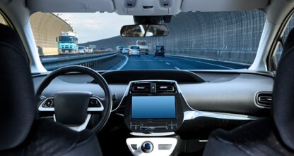 View from inside a car showing the dashboard, steering wheel, and front seats while driving on a multi-lane highway, much like commuting to a corporate law office or meeting with lawyers in Chicago. Several vehicles are visible ahead.