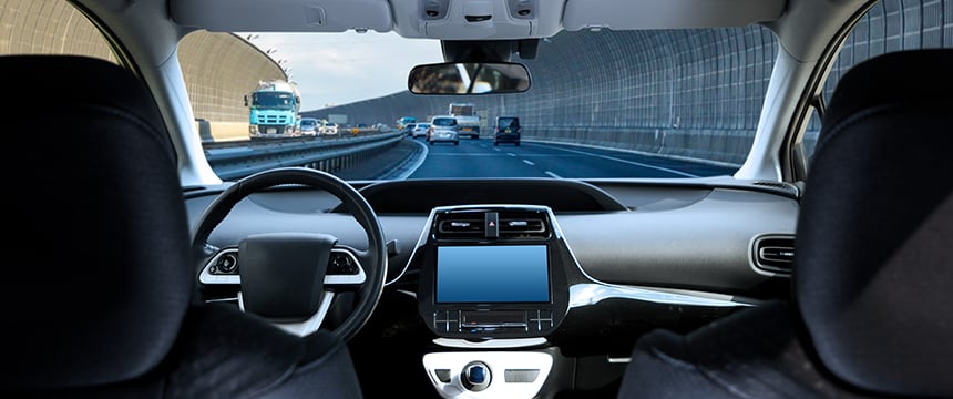 View from inside a car showing the dashboard, steering wheel, and front seats while driving on a multi-lane highway, much like commuting to a corporate law office or meeting with lawyers in Chicago. Several vehicles are visible ahead.