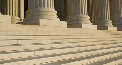 Wide stone steps lead up to large, fluted columns on a classical building facade, evoking the prestige often associated with law offices or a corporate law office in Chicago.