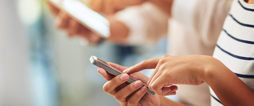 Two people using smartphones, one tapping on the screen while the other holds their phone in the background—perfect for illustrating how chicago lawyers stay connected outside their law offices.