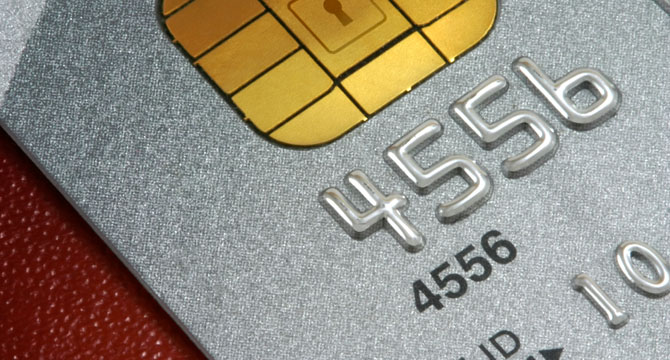 Close-up image of a credit card showing the chip and part of the embossed card number on a metallic silver surface, ideal for chicago lawyers seeking litigation support in financial cases.