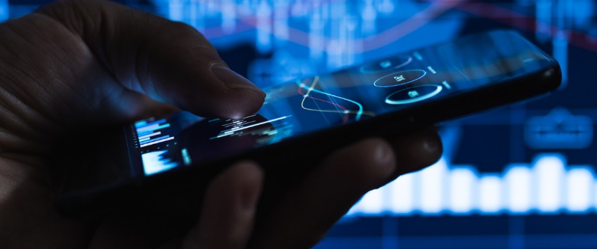 Close-up of a hand holding a smartphone with financial graphs and charts displayed in the background, illustrating litigation support tools used by law offices and lawyers in Chicago.