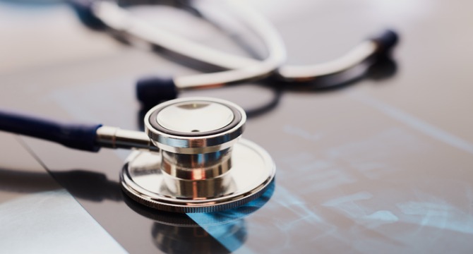 A stethoscope rests on top of an X-ray film, symbolizing medical examination and healthcare diagnostics, much like how law offices support clients with litigation support in complex cases.