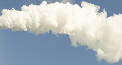 A tall industrial smokestack releases a large plume of white smoke into a clear blue sky, mirroring the need for litigation support often required by lawyers in Chicago.