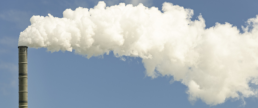 A tall industrial smokestack releases a large plume of white smoke into a clear blue sky, mirroring the need for litigation support often required by lawyers in Chicago.