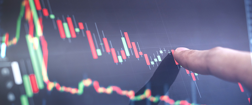 A hand points at a digital screen displaying a candlestick chart with fluctuating red and green lines, representing financial market data—ideal for use by law offices offering litigation support in financial cases.