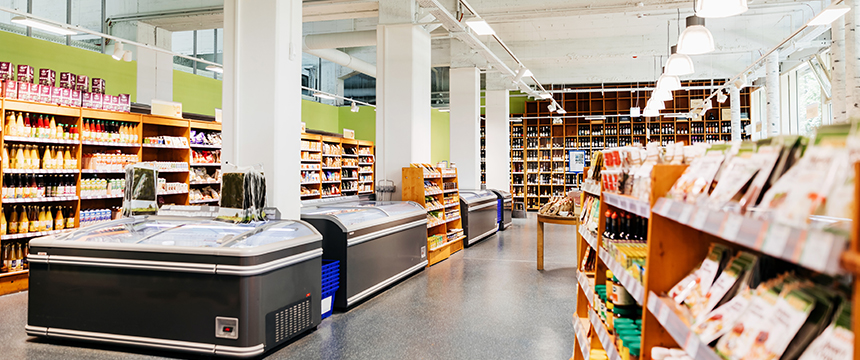 Interior of a grocery store with shelves of packaged goods, freezers in the center, and products neatly organized under bright lighting—efficiency and order that even Chicago lawyers might admire.