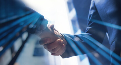 Two people in business attire shake hands outdoors with light streak effects, symbolizing a successful partnership at a corporate law office or between lawyers in Chicago.