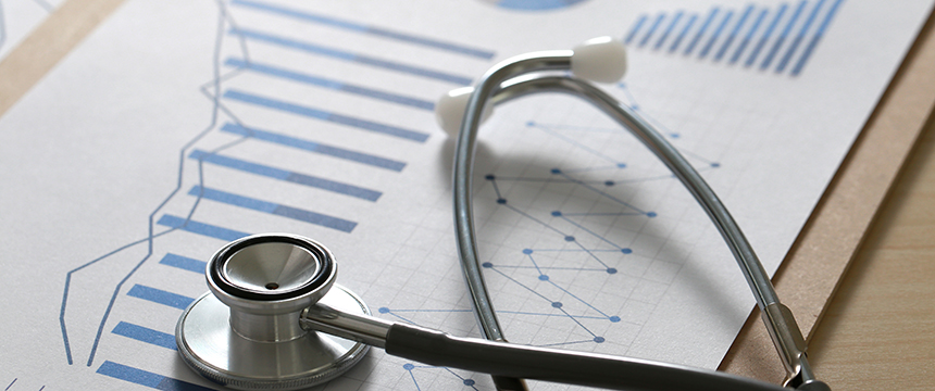 A stethoscope rests on a sheet of paper displaying blue bar and line graphs, suggesting a connection between healthcare data analysis and litigation support in law offices.