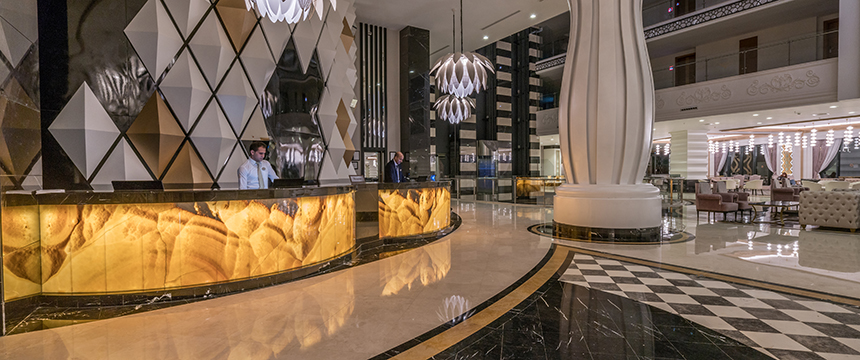 Elegant lobby with modern geometric decor, marble floors, illuminated front desk, and staff ready to assist—perfect for a corporate law office seeking a refined and professional atmosphere.