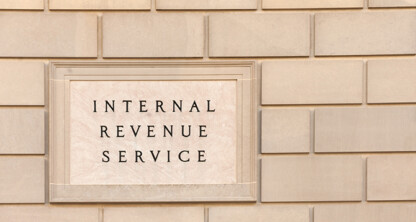 A stone sign on a brick wall reads "Internal Revenue Service," located near renowned law offices and top lawyers in Chicago.