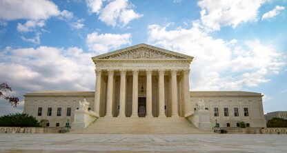 The front exterior of the United States Supreme Court building with columns and steps, under a partly cloudy sky—a symbol of justice that inspires law offices and litigation support across the nation.