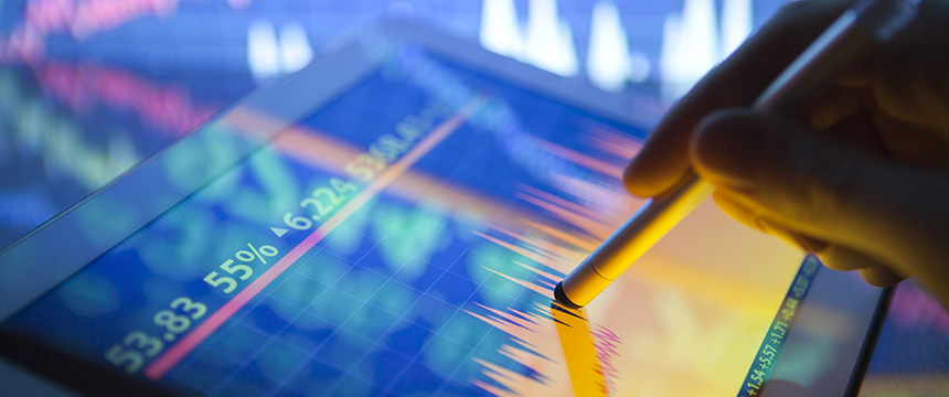 A hand uses a stylus on a tablet displaying colorful financial graphs and stock market data—an essential tool in any corporate law office or for chicago lawyers specializing in intellectual property law.