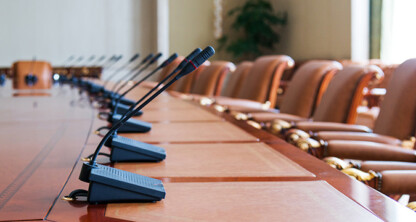 A long conference table with microphones and empty chairs arranged around it, ready for lawyers in Chicago to discuss intellectual property law and provide litigation support in a meeting room.