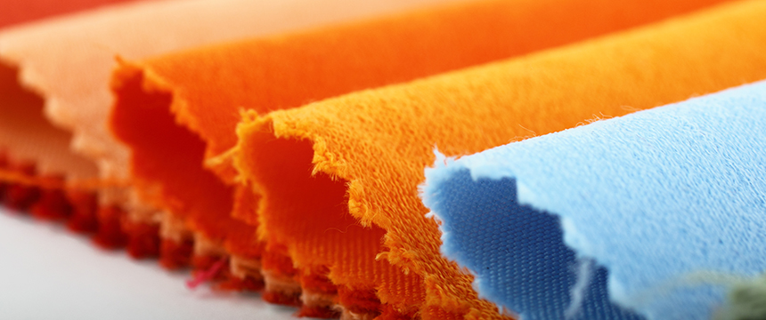 Close-up of several fabric swatches in orange and blue tones with pinked, zigzag edges, arranged in overlapping rows—an image often seen in corporate law offices or among Chicago lawyers specializing in intellectual property law.