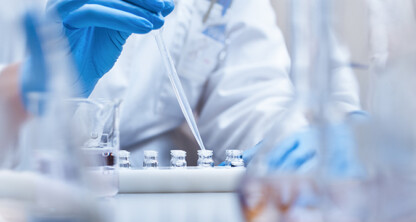 A person wearing blue gloves uses a pipette to transfer liquid into small vials in a laboratory setting, supporting litigation support for lawyers in Chicago through accurate scientific analysis.