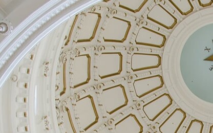 Interior view of a domed ceiling, reminiscent of the refined elegance often found in prestigious law offices, featuring a central star surrounded by ornate molding and geometric patterns.