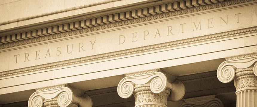 Close-up of the stone facade of a corporate law office with "Treasury Department" engraved above a row of classical columns.