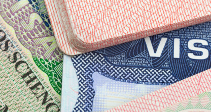 Close-up of several passports and visas stacked together, showing official stamps, security patterns, and visa labels from different countries—ideal for law offices specializing in immigration or intellectual property law.