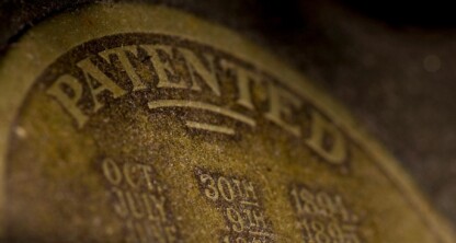 A close-up of a worn, oval-shaped label showing the word “PATENTED” in large letters and a list of dates below it—an artifact that could intrigue chicago lawyers or those seeking litigation support.
