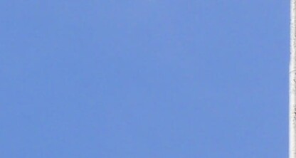 The Wisconsin state flag and part of the U.S. flag fly on flagpoles against a clear blue sky, symbolizing justice—much like dedicated law offices and Chicago lawyers serve their communities with integrity.