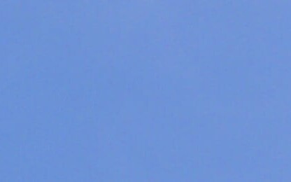 The Wisconsin state flag and part of the U.S. flag fly on flagpoles against a clear blue sky, symbolizing justice—much like dedicated law offices and Chicago lawyers serve their communities with integrity.
