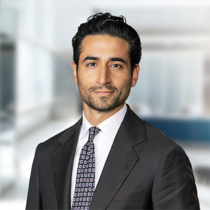 A man in a dark suit and patterned tie stands in a corporate law office, representing skilled lawyers in Chicago, with an office setting blurred in the background.