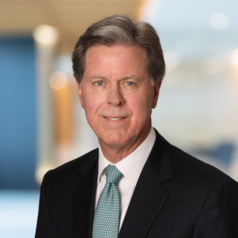 A middle-aged man in a suit and tie poses for a professional headshot against a blurred office background, reflecting the expertise and professionalism found in Chicago lawyers and top law offices.