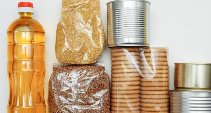 Assorted non-perishable food items, perfect for Chicago lawyers or law offices needing convenient snacks—includes a bottle of cooking oil, two types of grains in plastic bags, round biscuits in plastic, and three tin cans.