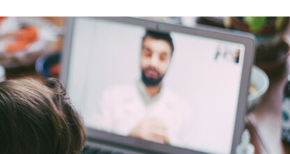 A person and a child are sitting in front of a laptop displaying a video call with a man in a white coat, seeking litigation support from a corporate law office.