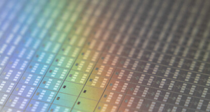 Close-up of a silicon wafer showing rows of microchips with a rainbow pattern reflecting off the surface, symbolizing the precision and innovation behind litigation support trusted by leading lawyers in Chicago.