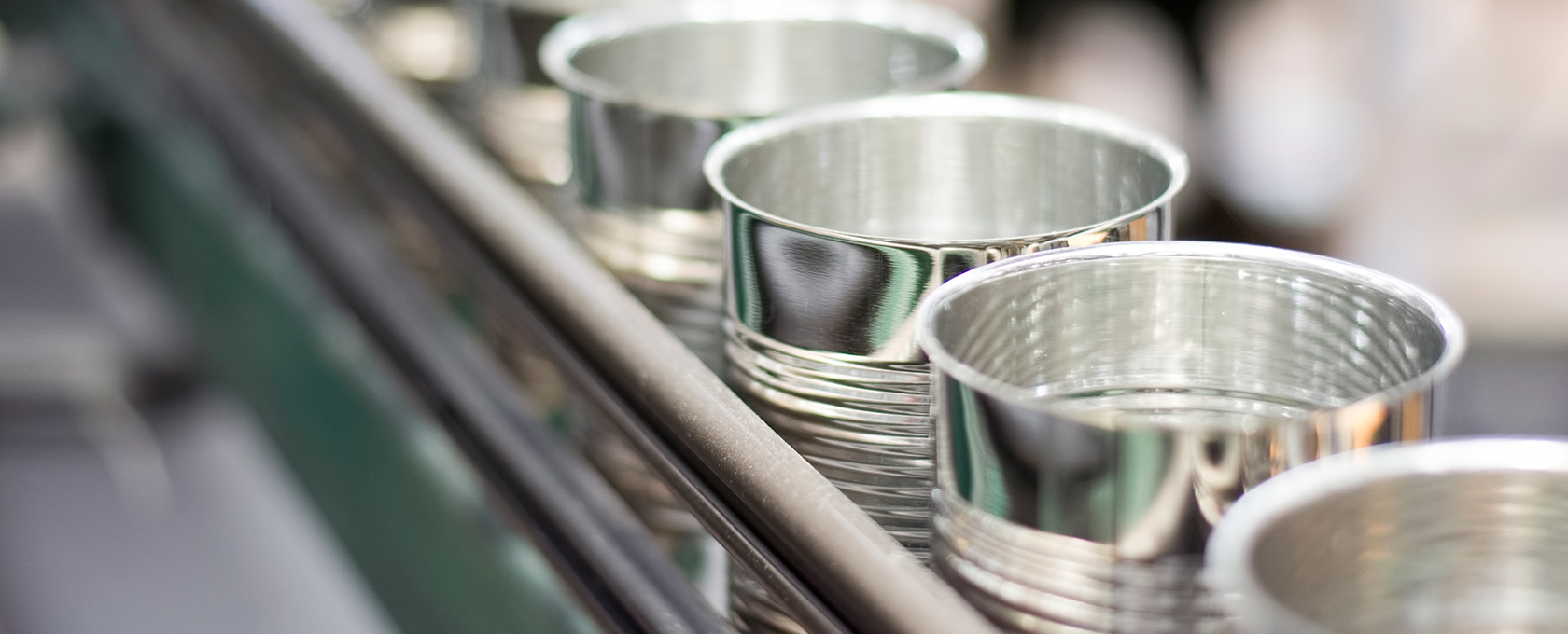 Close-up of empty, silver metal cans aligned in a row on a production line, similar to the precision and order found in top Chicago law offices.