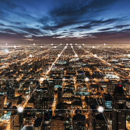 Aerial view of a city at night with illuminated grid-like streets and buildings under a cloudy sky, lines and dots digitally added to emphasize the city grid layout, reflecting the structured precision found in top law offices.